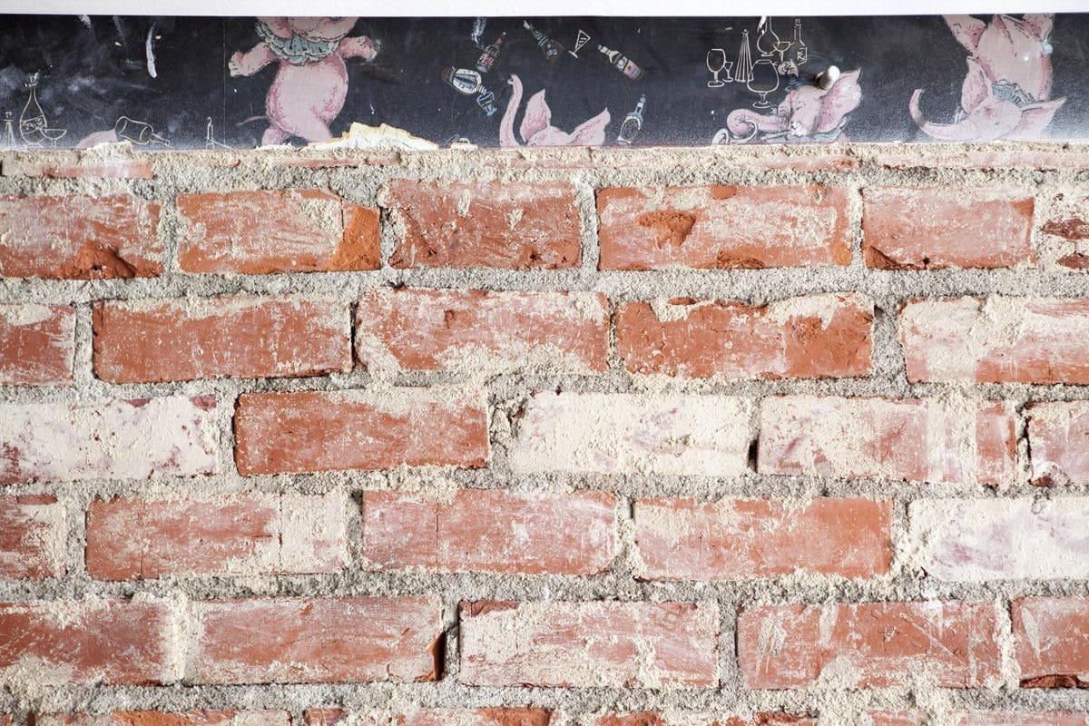 Vue d'un mur de l'intérieur du restaurant cadet à Los Angeles. Mur de briques, avec les traces d'un ancien papier peint vintage illustrant des petits éléphants. Bricks and éléphant wallpaper at Cadet restaurant, at Los Angeles.