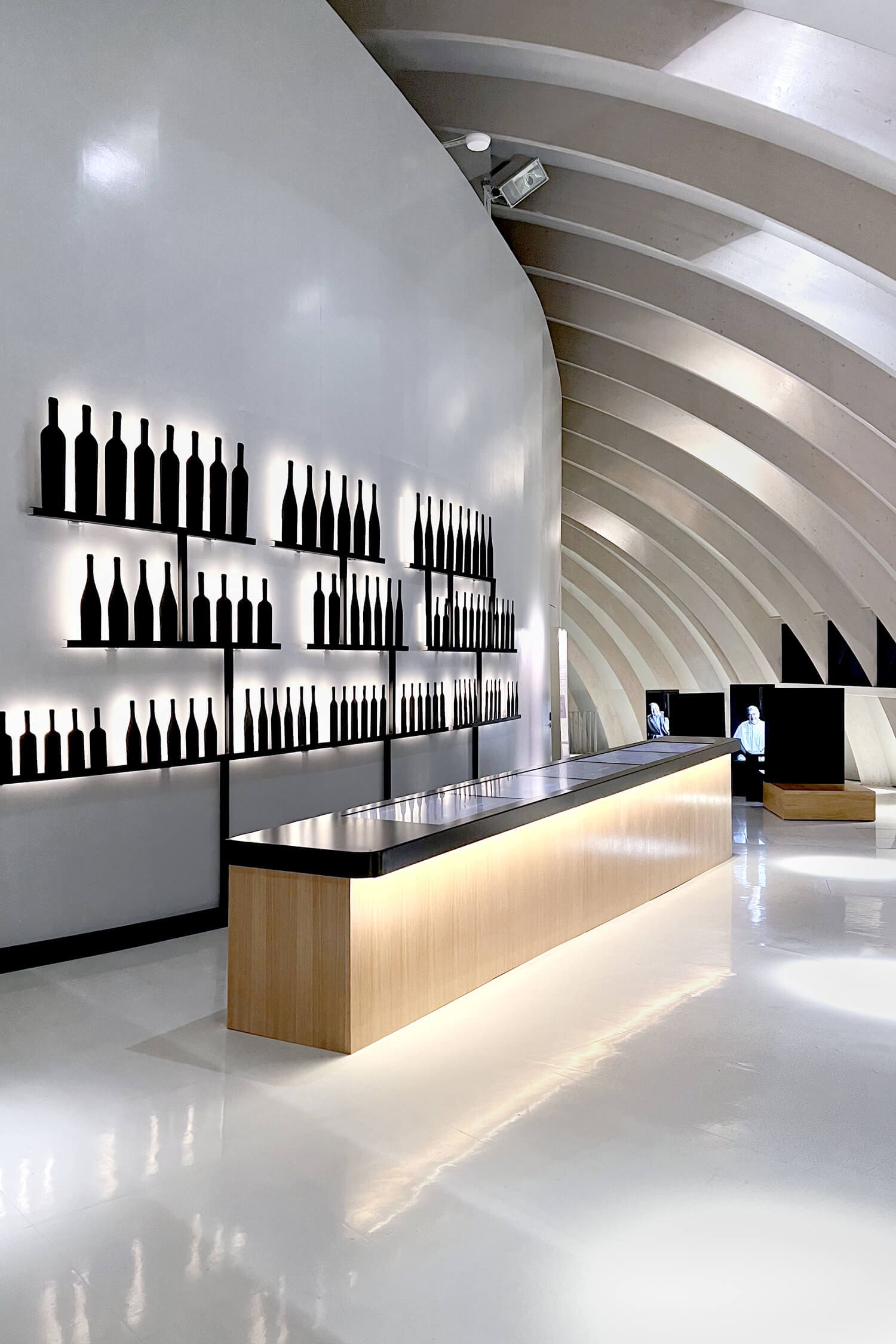l'espace le vin et moi à la cité du vin de Bordeaux s'articule autour d'un bar avec un jeu en écran tactile et d'un mur de bouteille en metal noir, design IchetKar