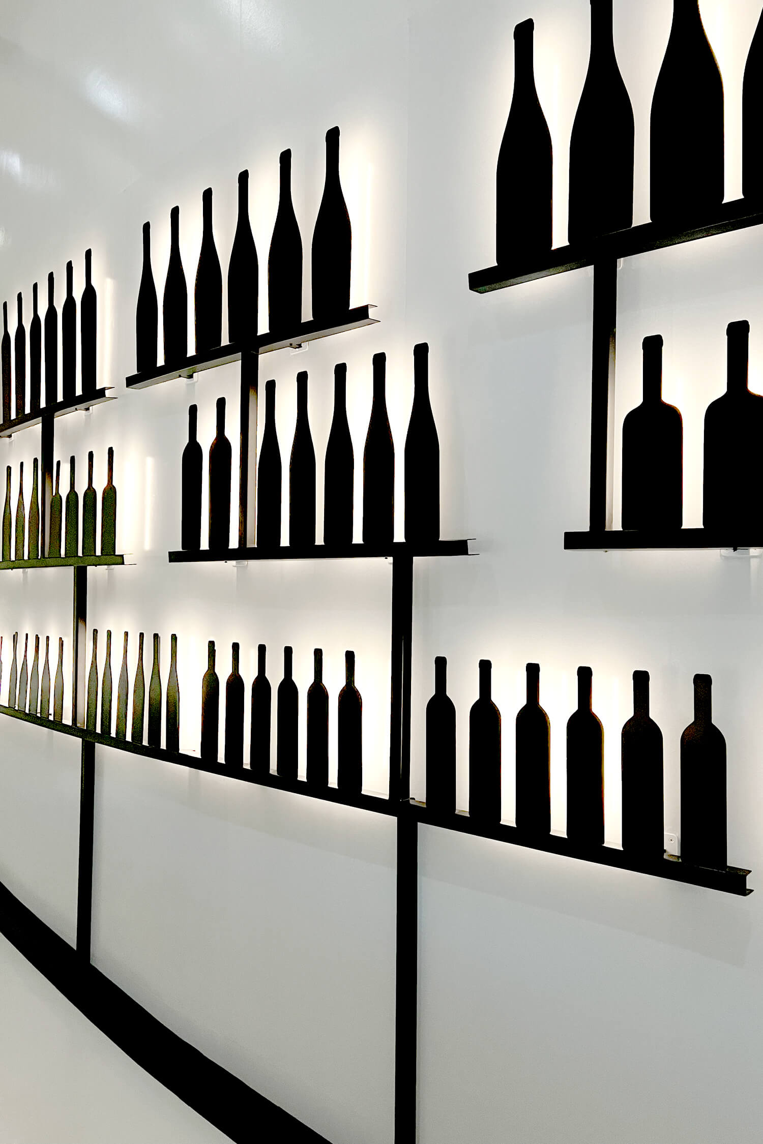 Les bouteilles en metal noir dessine par IchetKar sont rétro éclairées et habille le mur de la cité du vin de Bordeaux