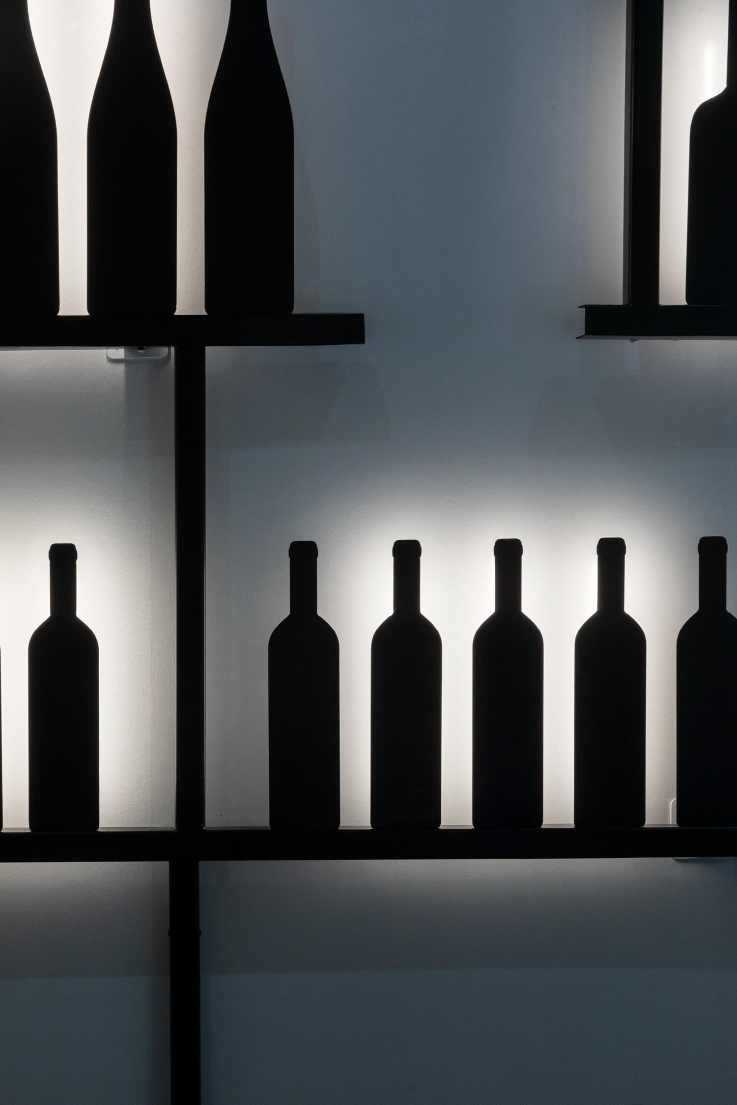 Zoom sur les bouteilles rétro éclairées de l'espace le vin et moi à la cité du vin de Bordeaux, design IchetKar
